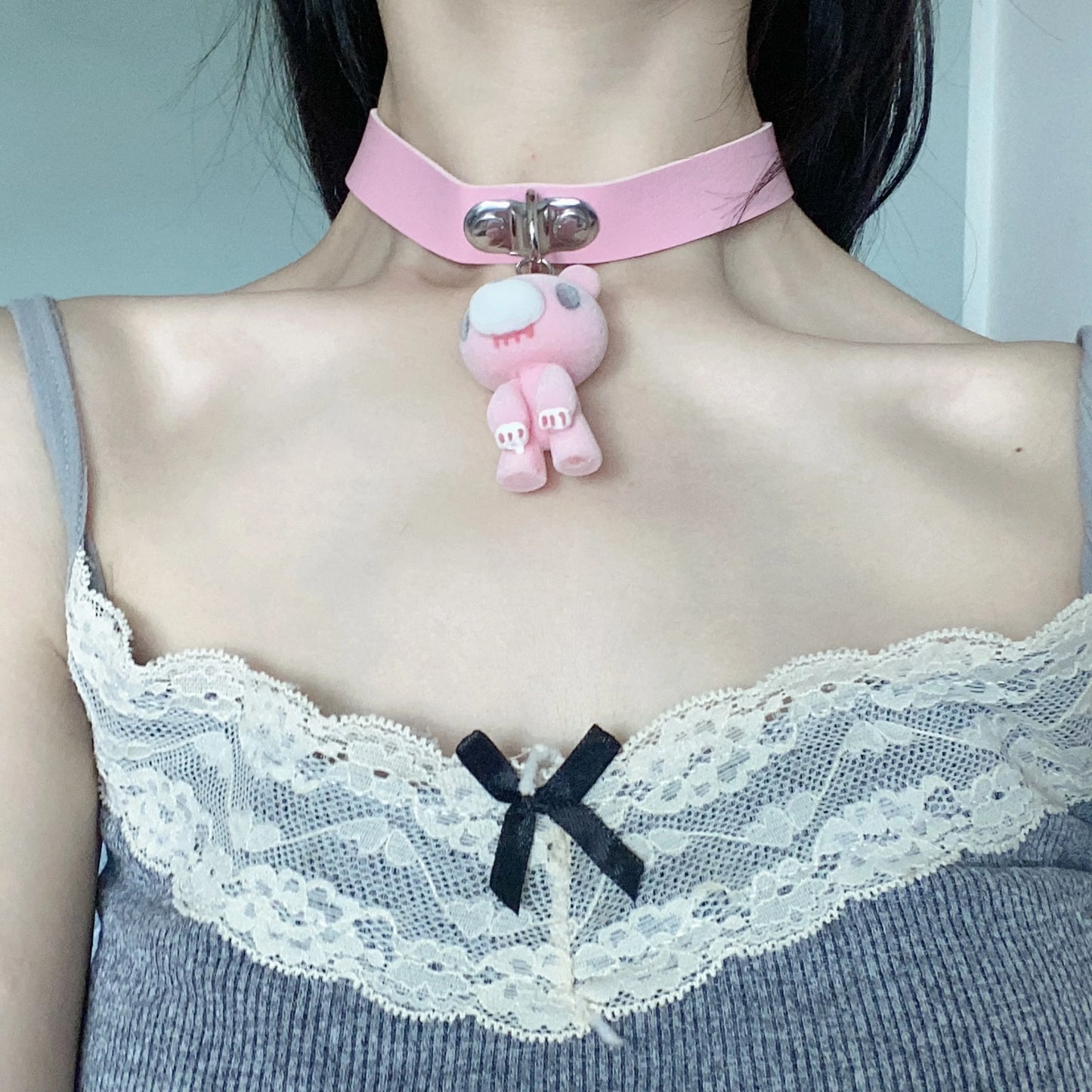 Esta gargantilha rosa apresenta um lindo pingente de Urso Sombrio. A tira de couro macio e o design adorável adicionam um toque doce e ousado.